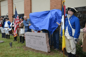 Descendants reveal the monument as members of the Missouri SAR Color Guard look on.
